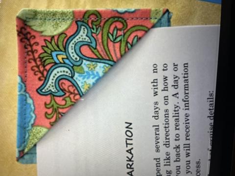 Close up of a fabric corner bookmark on a book page.