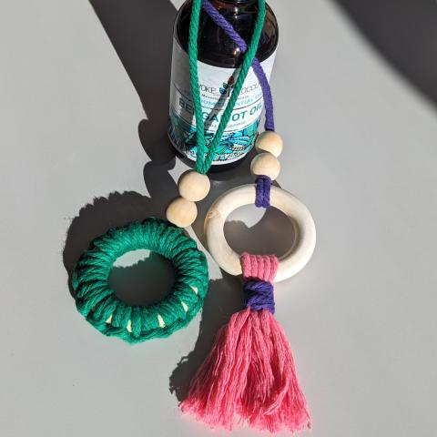 Examples of the macrame essential oil diffusers. One is wrapped with green cord and the other has a pink and purple tassel.